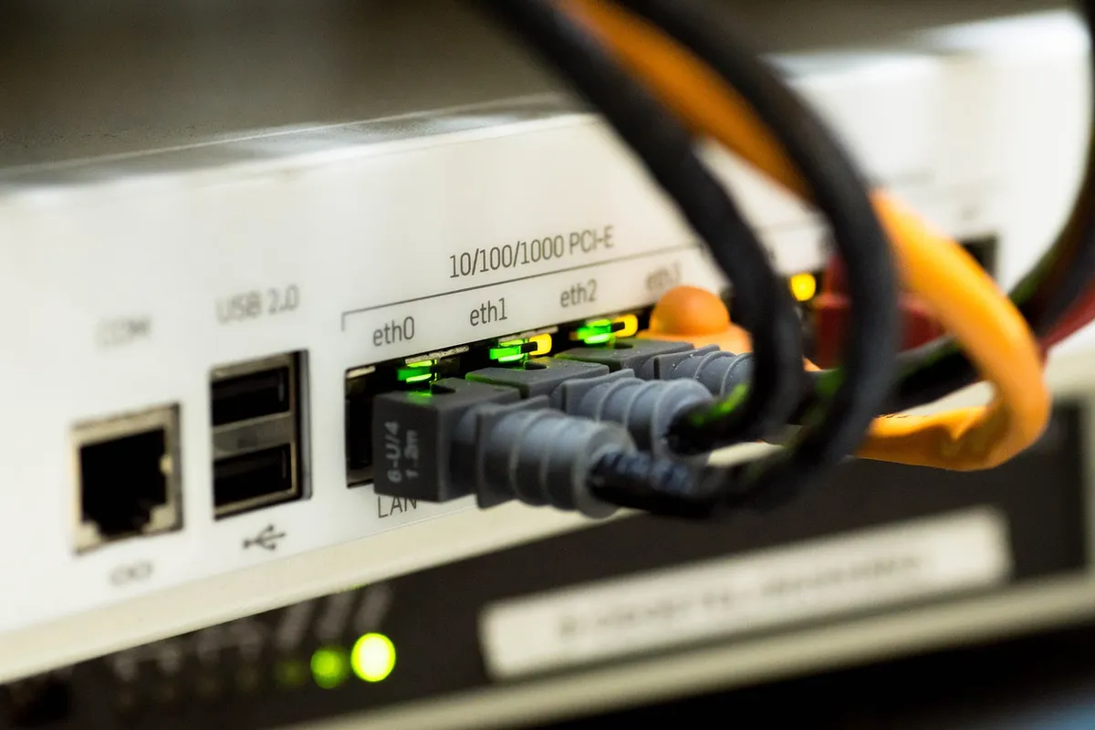 Porturile unui router cu cabluri ethernet conectate și leduri verzi aprinse