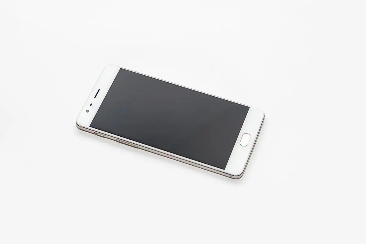 Smartphone alb cu senzor de amprentă pe partea din față, folosit pentru deblocarea biometrică