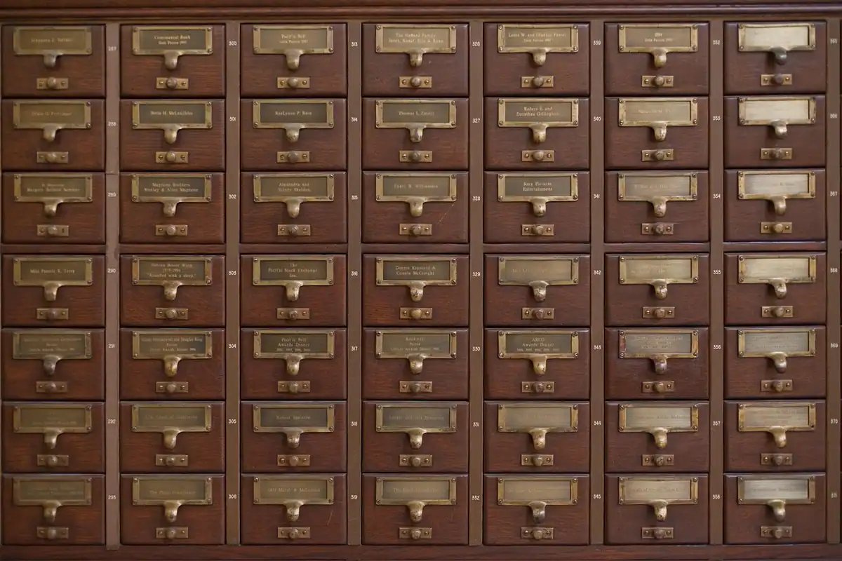 Fișier vechi de bibliotecă din lemn, cu sertare ordonate ca rândurile unui tabel