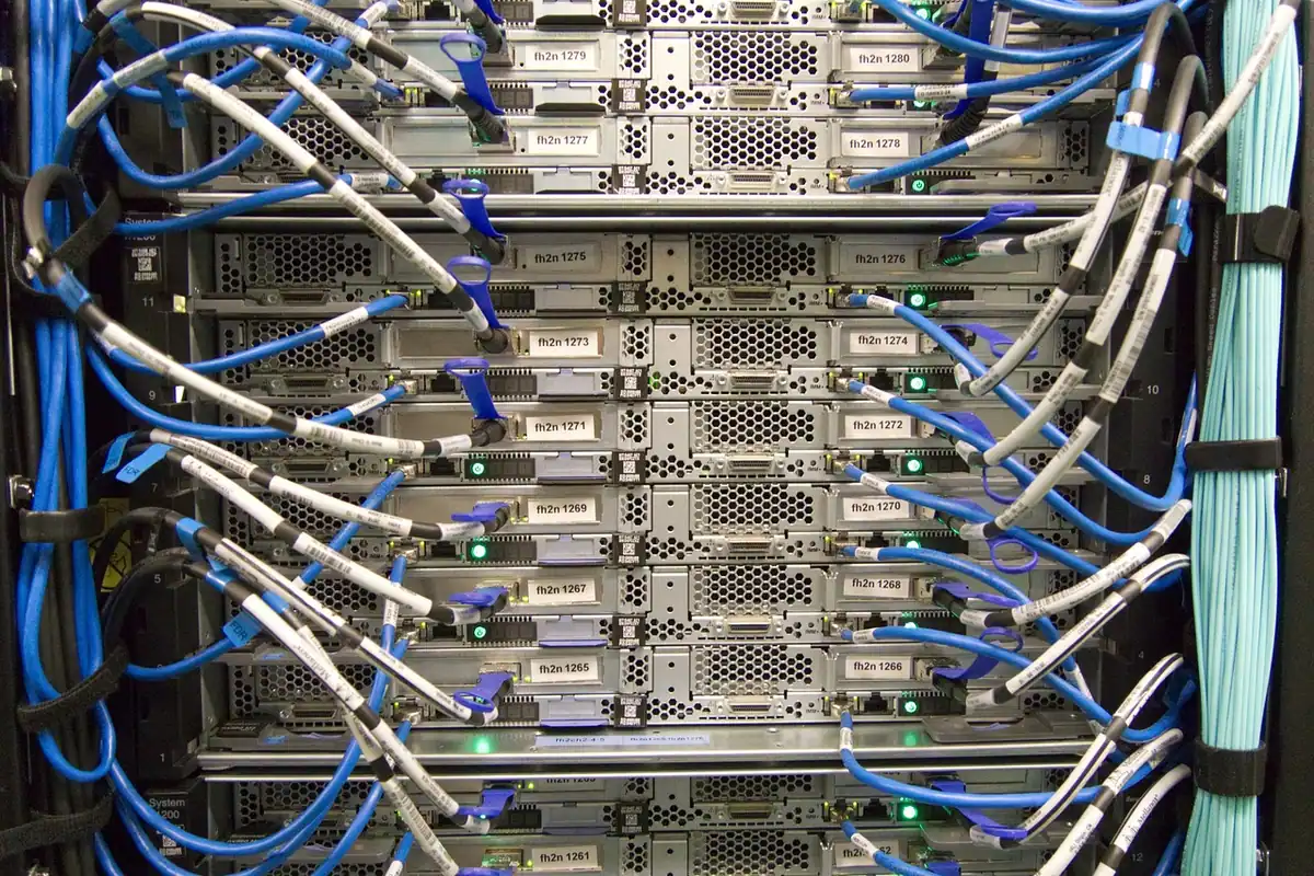 Servere dintr-un rack conectate prin numeroase cabluri de rețea albastre