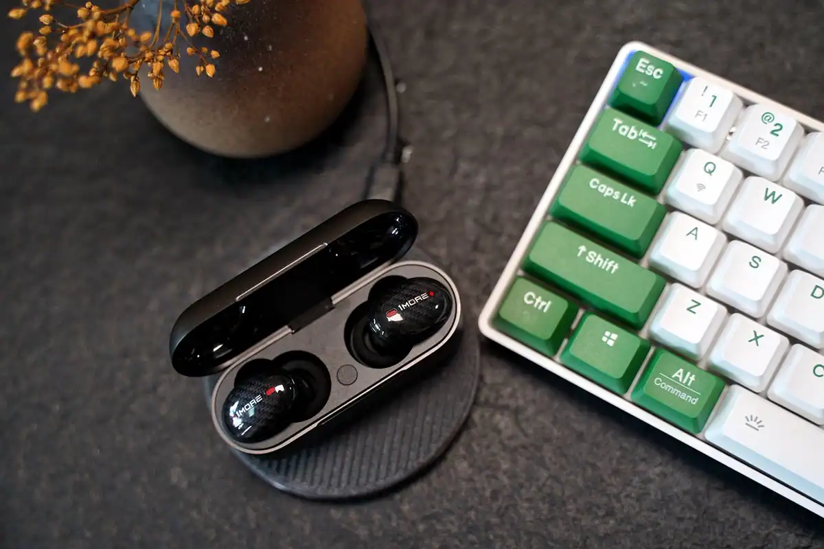 Căști wireless intra-auriculare lângă carcasa lor de încărcare, gata de conectat prin Bluetooth