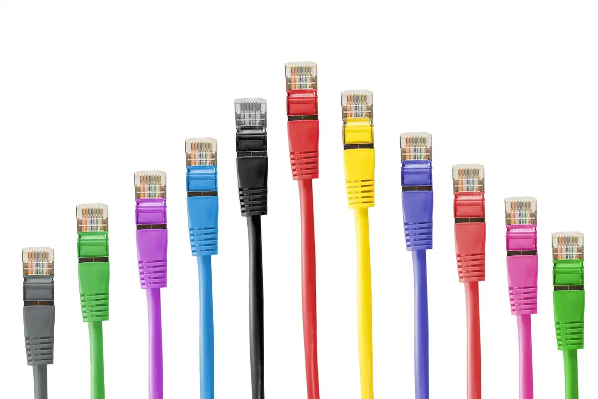 Cabluri Ethernet colorate încâlcite între ele, cu mufe RJ45 vizibile la capete