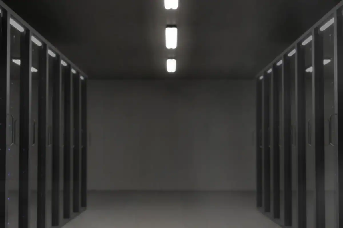 Culoar între dulapuri de servere într-o sală de date slab luminată