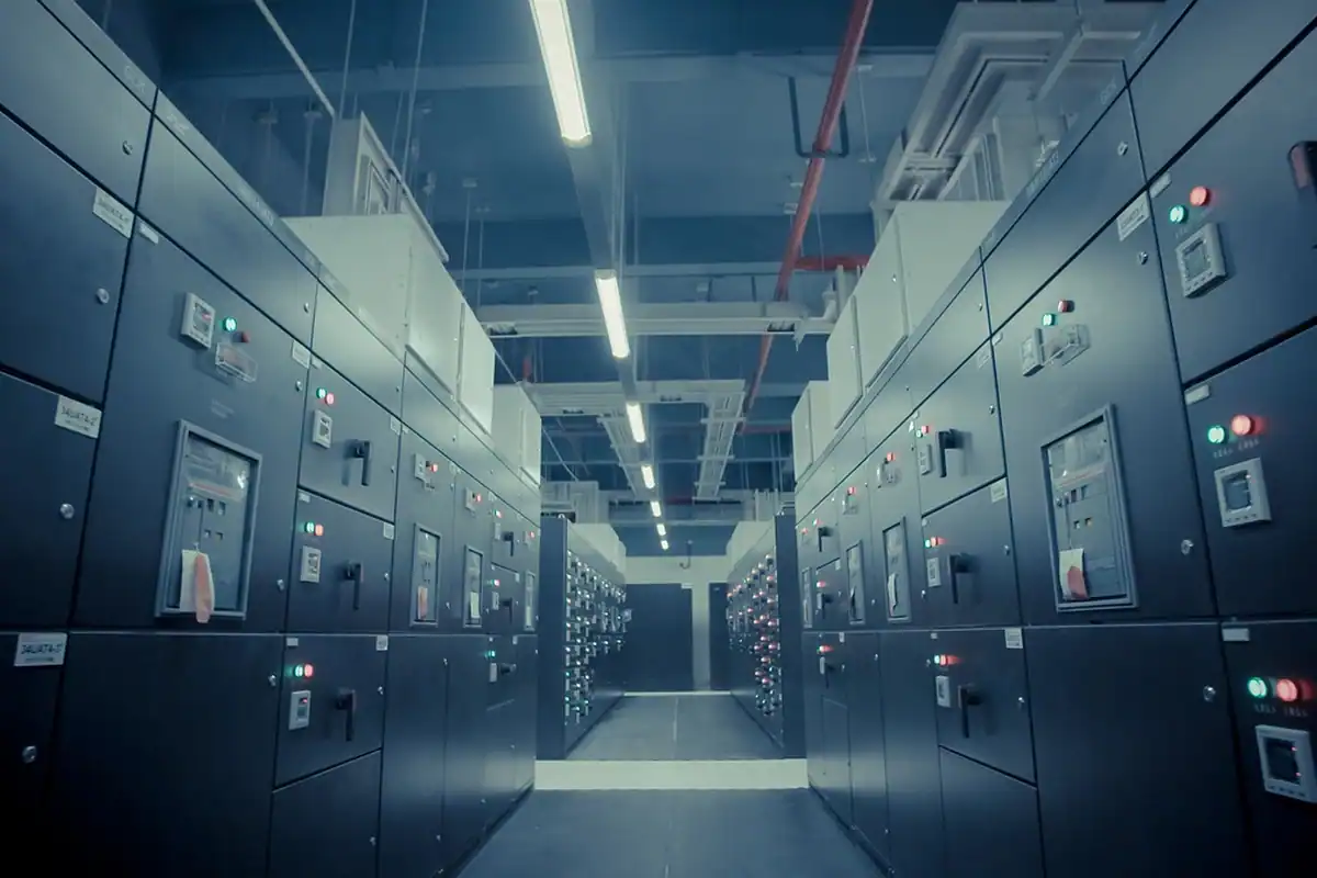 Culoar lung cu dulapuri electrice și de servere într-un centru de date