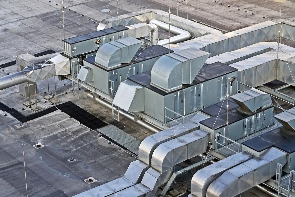 Instalații mari de climatizare și tubulatură pe acoperișul unei clădiri industriale