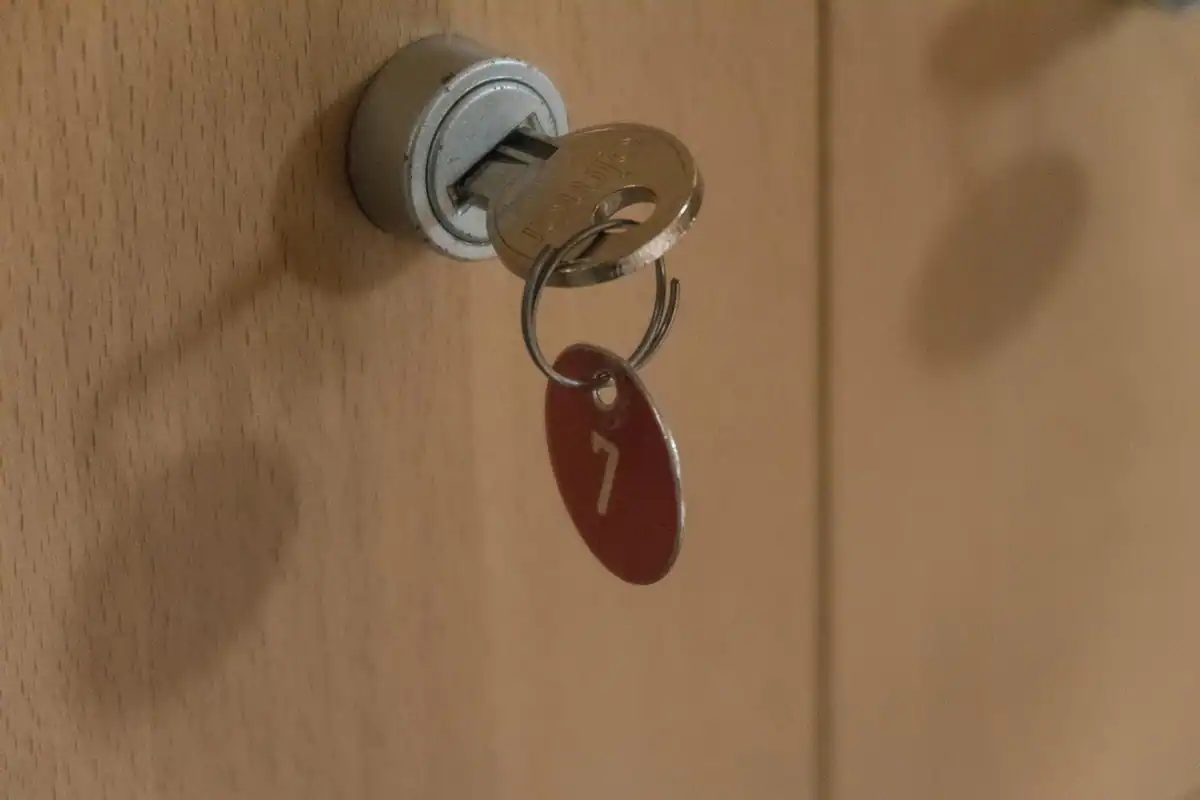Cheie metalică într-o broască de dulap încuiat, simbol al securității datelor dintr-un cloud privat