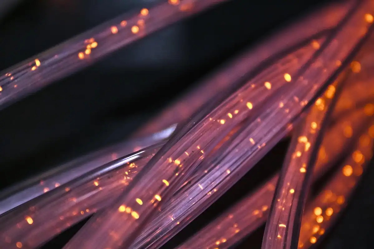Mănunchi de fibre optice violet prin care călătoresc puncte de lumină
