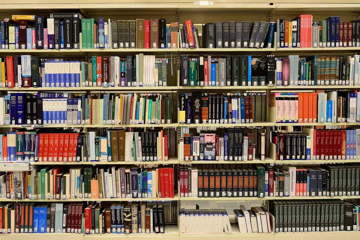 Rafturi pline cu cărți într-o bibliotecă, sursă de texte pentru învățare