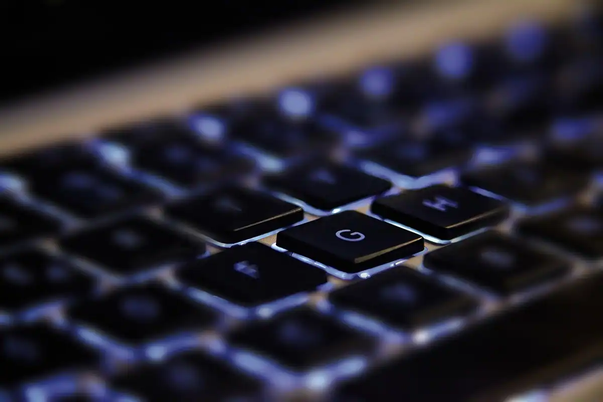 Tastatură iluminată de laptop în lumină albastră, fotografiată de aproape