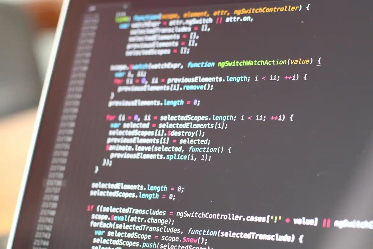 Ecran de laptop cu linii de cod pentru o aplicație web, din unghi înclinat