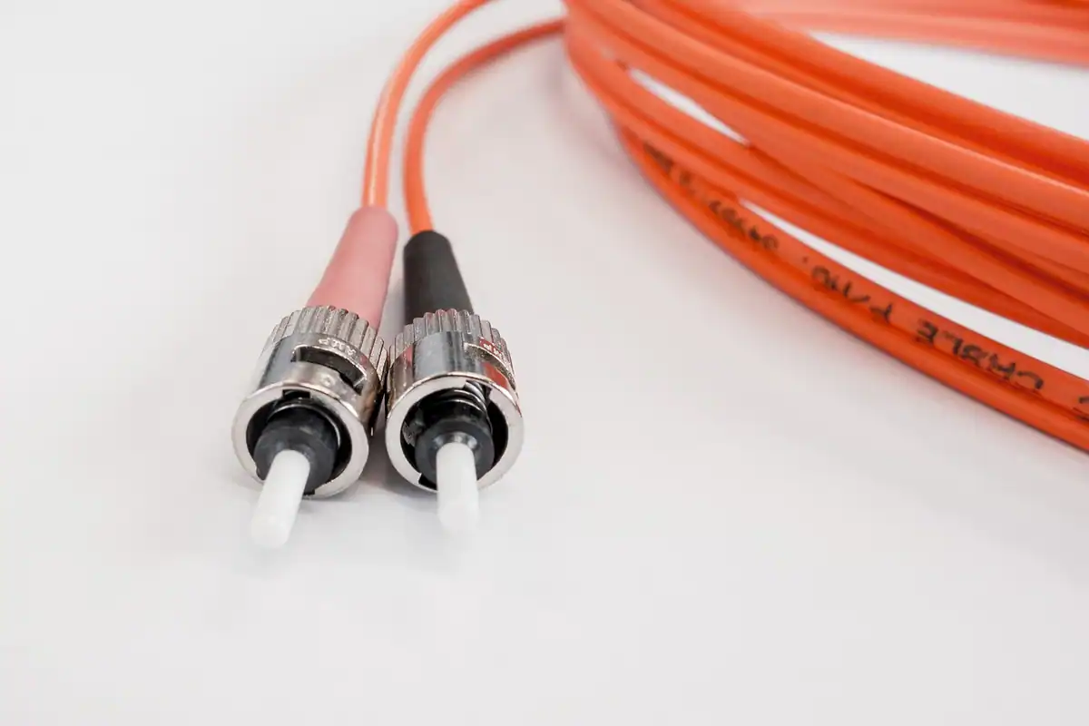 Conector de cablu cu fibră optică cu lumină verde la capăt, folosit la conexiuni de internet