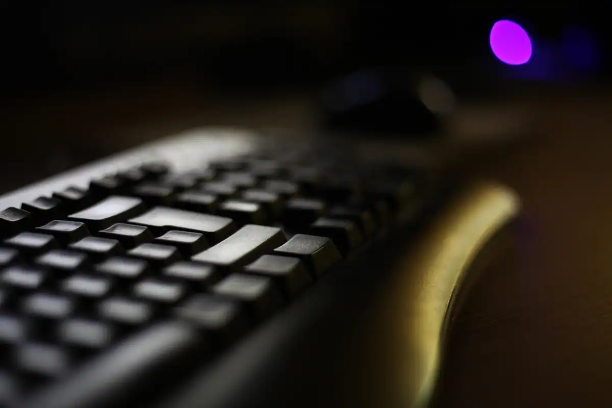 Tastatură neagră în semiîntuneric, pe care se introduc zilnic parolele