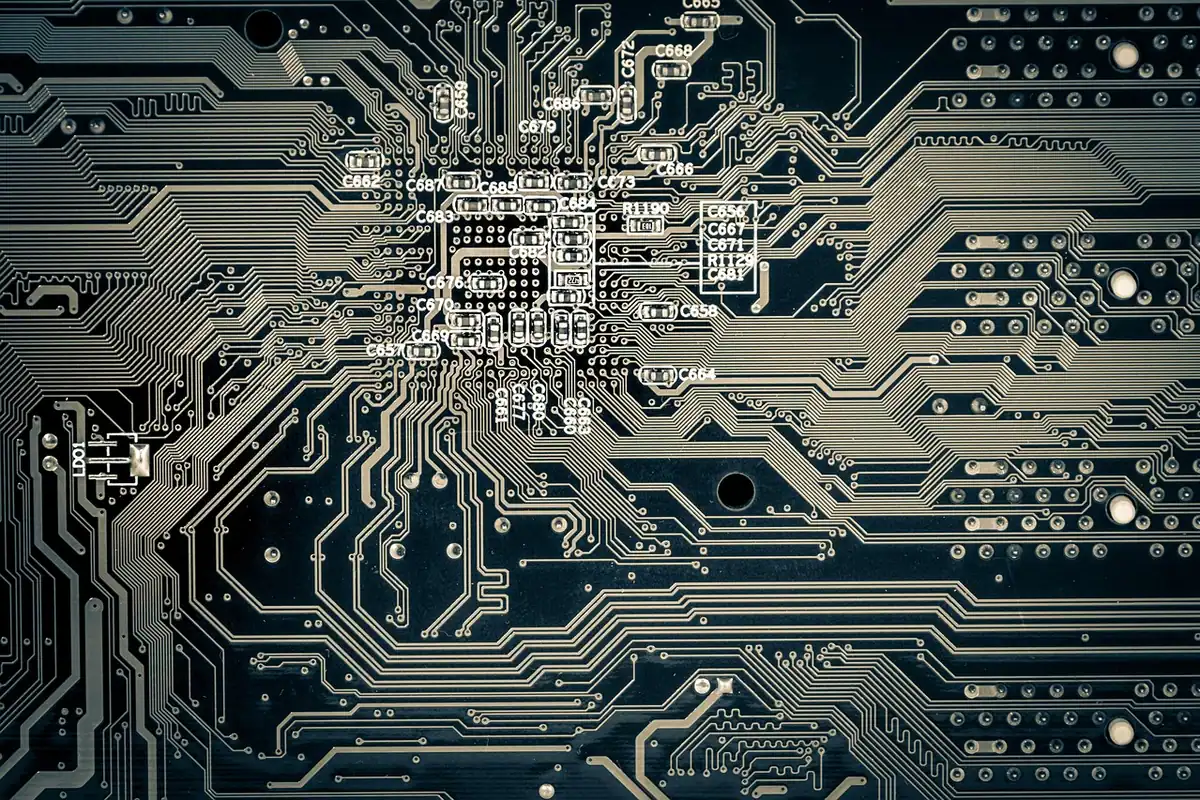 Placă de circuit cu componente lipite și trasee metalice, fotografiată de aproape