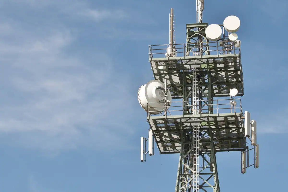 Turn de telecomunicații cu antene și parabole pe un cer ușor înnorat