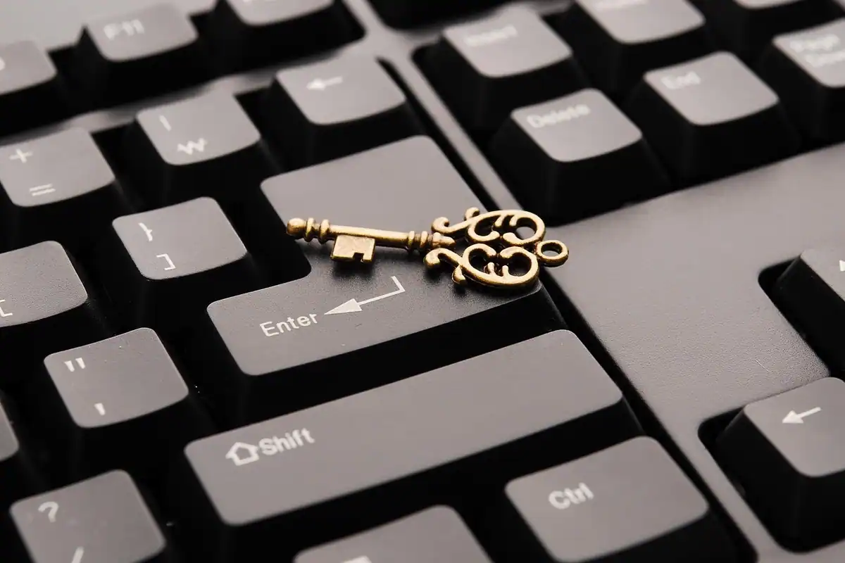 Cheie aurie așezată pe tastatura unui calculator, lângă tasta Enter