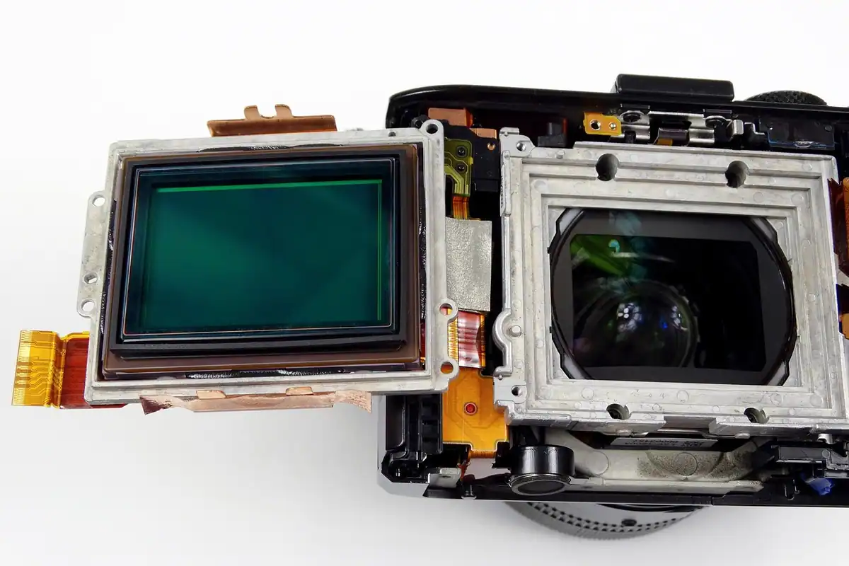 Aparat foto compact cu senzor full-frame, așezat pe o masă, văzut din lateral