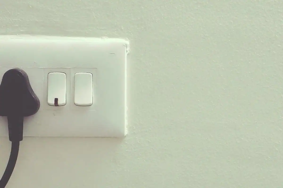 Adaptor conectat într-o priză de perete, cu lumină verde aprinsă, pentru alimentare electrică
